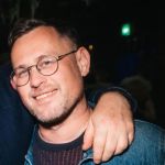 Mark Pendleton: mark is smiling and wearing round glasses and has short hair.