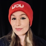 Laura Chuhan Campbell: Laura is wearing a dark top and a pink UCU beanie hat. She has long dark hair with blonde streaks.