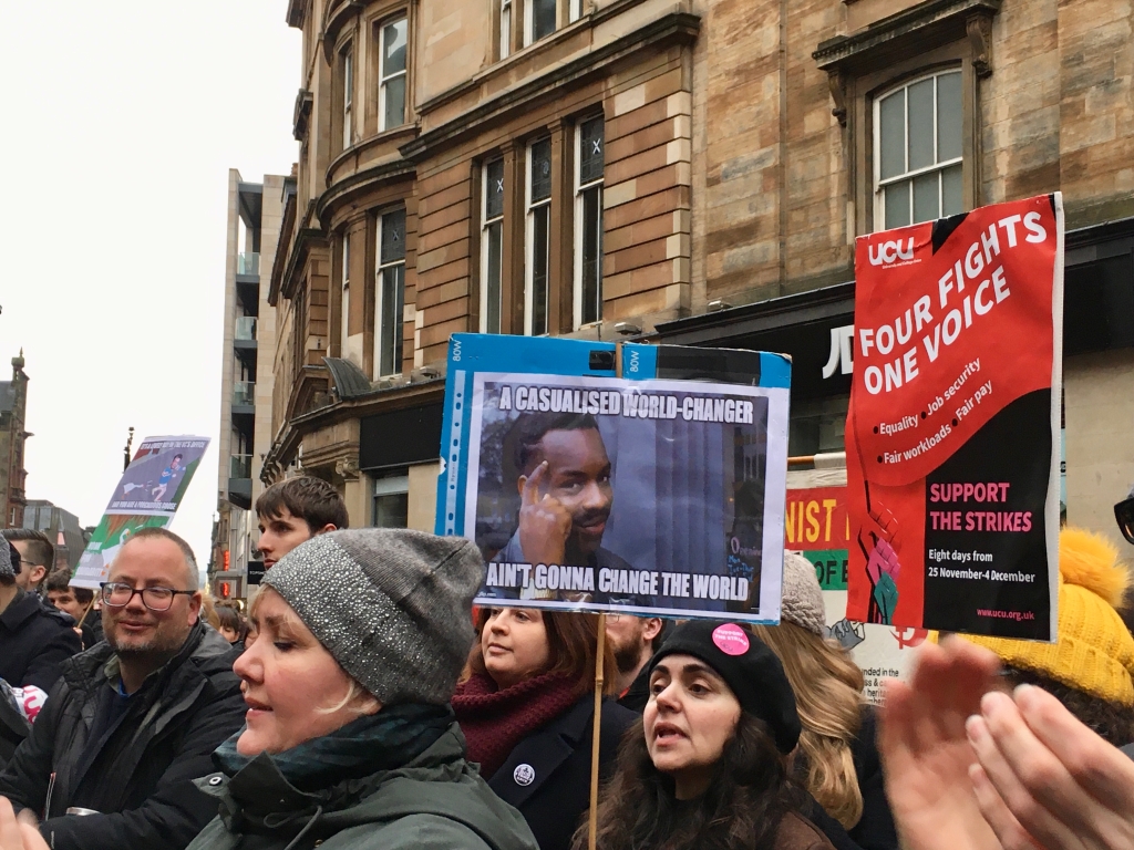 UCU Strikers in Glasgow, with one holding a sign saying that casualised world changers aren't going to change the world.