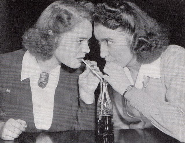 Photograph of two students sharing a bottle of Coca-Cola at Shimer College in 1941-1942, from the 1942 yearbook of Shimer Col